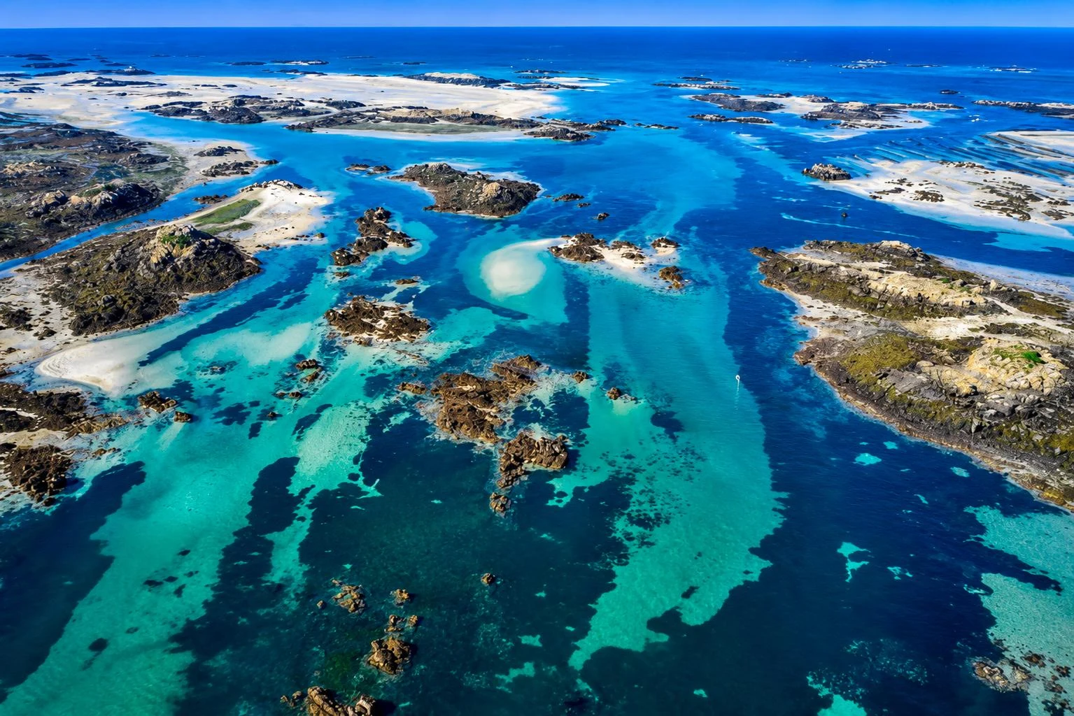 Turquoise tidal channels between the islands off Normandy